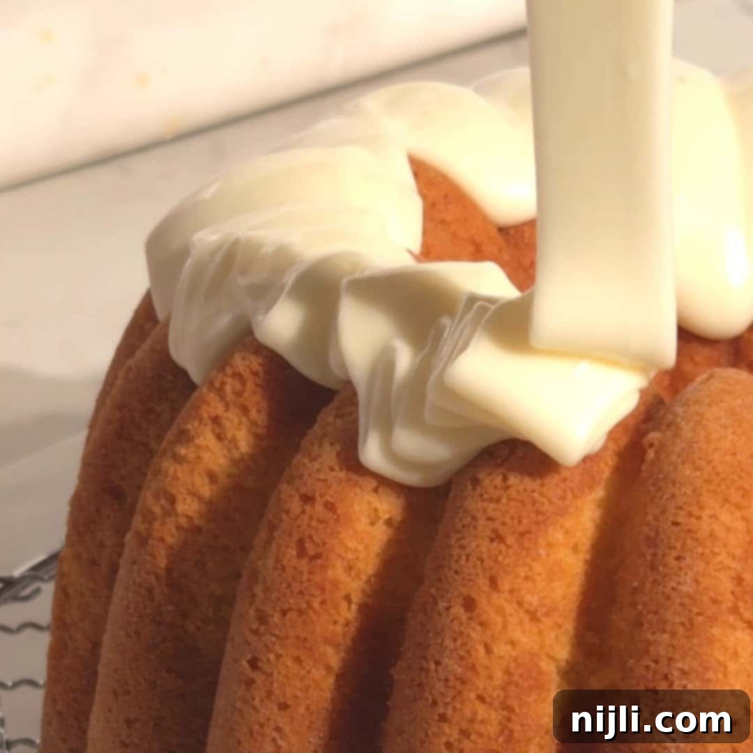 Drizzling rich, creamy eggnog glaze over the cooled pound cake for a beautiful and flavorful finish.