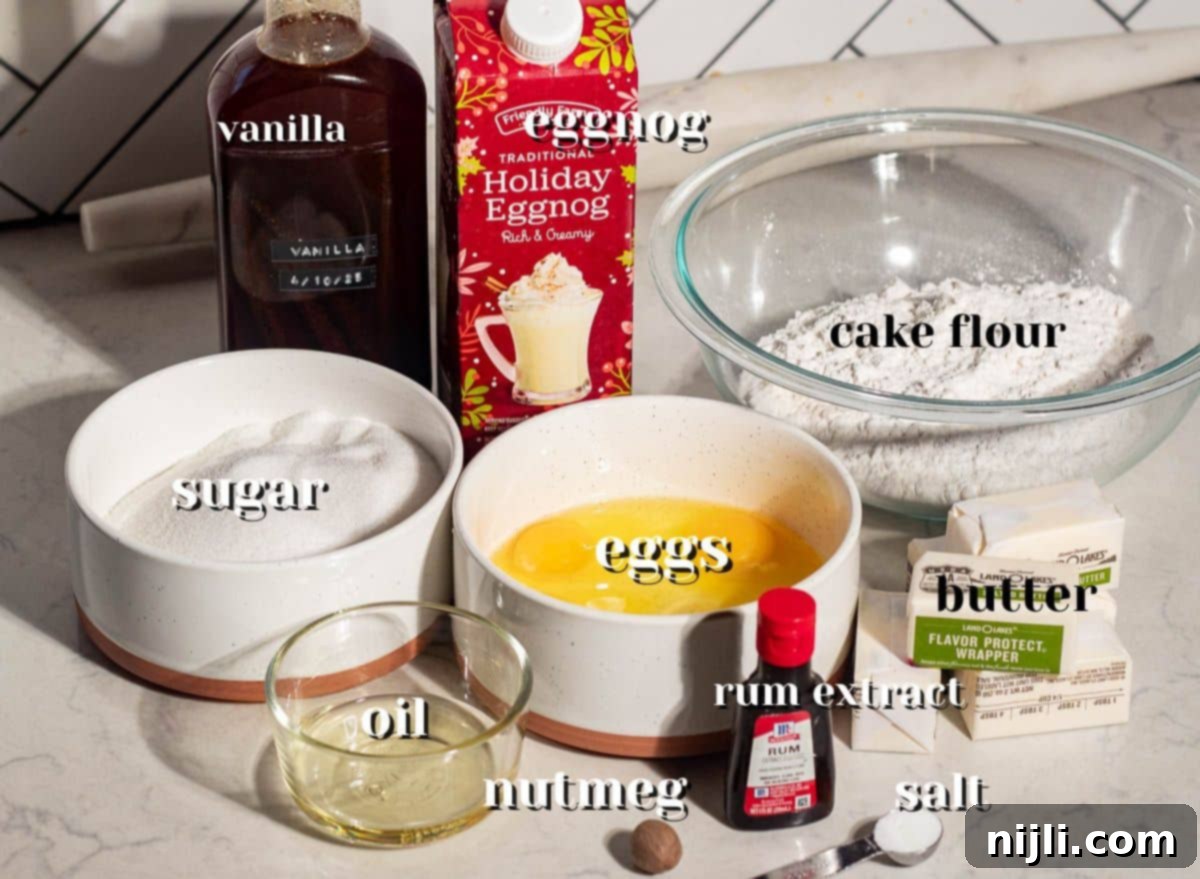 Labeled ingredients for eggnog pound cake including cake flour, sugar, butter, eggs, vanilla, rum extract, and holiday eggnog.