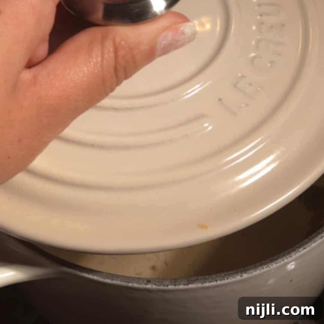 Covering the saucepan to let the cardamom syrup steep and infuse with spice.